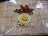 Espárragos confitados con yema de huevo empanada, salteado de setas de primavera y jamón crujiente