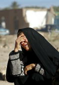 BAM, IRAN: A woman despairs sitting among the rubble in the earthquake stricken city of Bam, 04 January 2004. As many as 30,000 people are feared dead after the earthquake mostly levelled the town on 26 December 2003. Photo credit ODD ANDERSEN/AFP/Getty Images