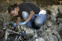 British forensic expert Sharna Daley unearths remains during an exhumation of eight mass graves found in the village of Kamenica, at the outskirts of the eastern Bosnian town of Zvornik, July 6, 2006. Forensic experts have so far unearthed the remains of 33 complete and 235 incomplete bodies of the victims of the 1995 Srebrenica massacre of about 8,000 Bosniaks (Bosnian Muslims) by the Bosnian Serb forces. REUTERS/ Danilo Krstanovic (BOSNIA AND HERZEGOVINA) 