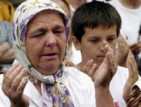 A Bosniak (Bosnian Muslim) woman from Srebrenica cries as trucks carrying 505 victims of the Srebrenica massacre pass down the main street in Sarajevo, Saturday, July 8, 2006. Trucks loaded with the coffins of the newly identified victims of Europe's worst massacre since World War II stopped for a few moments in Sarajevo on Saturday to allow hundreds of people to pay tribute to their beloved ones. The bodies will be buried at Srebrenica on the 11th anniversary of the massacre on Tuesday. (AP Photo/Hidajet Delic)(AP Photo/Hidajet Delic)