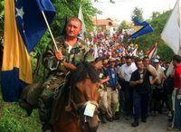 A Bosniak (Bosnian Muslim) man on horseback carries a Bosnian state flag at a start point of a four-day march to Srebrenica, in the village of Nezuk near Zvornik, 120 kms north of Sarajevo on Friday, July 7, 2006. Hundreds of Bosniaks (Bosnian Muslims) began a four-day march Friday along the route survivors used 11 years ago to escape the Bosnian Serb killings in Srebrenica, the worst massacre in Europe since World War II. (AP Photo/Almir Arnaut)
