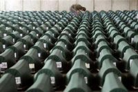  man searches through more than 600 coffins with remains of victims of Srebrenica massacre waiting for the funeral in a factory hall in Potocari on July 11, 2005. REUTERS/Danilo Krstanovic 