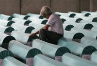 Bosniak (Bosnian Muslim) man cries near coffins of 505 newly identified Srebrenica victims at an abandoned battery factory in Potocari 120 kms north of Bosnian capital Sarajevo, Saturday, July 8, 2006. The bodies will be buried in Srebrenica on Tuesday during the 11th anniversary commemorations of the massacre. Serb troops killed some 8,000 Muslim men and boys at Srebrenica in 1995, and most of the bodies are still missing. (AP Photo/Amel Emric)