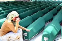 A Bosnian woman weeps next to the coffins of Srebrenica Massacre victims, Muslim men and children, before their burial in Potocari, near Srebrenica.