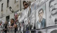 Bosnian women in Tuzla last week with photos of missing kin. They sought arrests of Bosnian Serb fugitives.