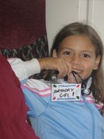 Lauren on the train to London, holding up a badge that says Birthday Girl