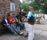 A horse drawn carriage goes past in Blists Hill