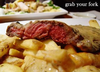 rare fillet steak with peppercorn sauce, chips and salad