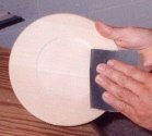 Sanding a basswood plate in preparation for woodburning.