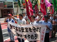 Trabajadores de JR manifestándose en contra de la tortura psicológica en el trabajo. La pancarta lee: JR West, respeta la seguridad. Eliminad la re-educación laboral.