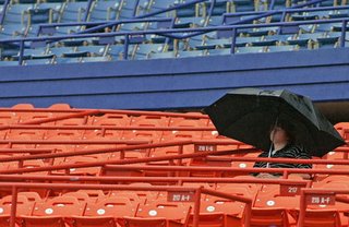 One lonely fan braves the rain delay, thousands of fans were packed onto the concourse of the field level