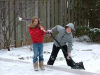 Kate and Laura shovelling the snow off the backyard rink
