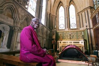 The Archbishop of York, John Sentamu, smiles after having his head shaved as part of his Sunday service at York Minster cathedral in York, northern England August 13, 2006. Image from REUTERS/Nigel Roddis 