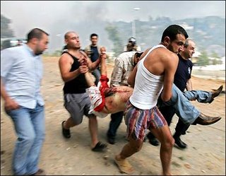 AP-July 17: Lebanese citizens carry a man who was killed by shrapnel from an explosion in Kfarshima, near Beirut, Lebanon.