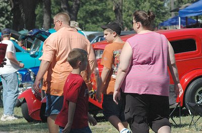 Image of overweight Americans at an outdoor car show