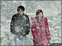 A Japanese couple walking in the snow.