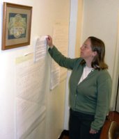 Robin M. examines handwritten responses to comments previously posted on her blog, printed out for the workshop.