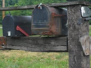 Ugly, beat up mailbox mounted on rail road tie posts
