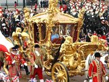 Queen Elizabeth II, accompanied by her husband Prince Philip, rides in the Gold State Coach from Buckingham Palace
