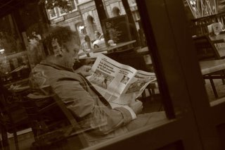 football, un homme lit les pages de sports dans un journal, place du marché à liège, belgique, photo dominique houcmant aka goldo graphisme