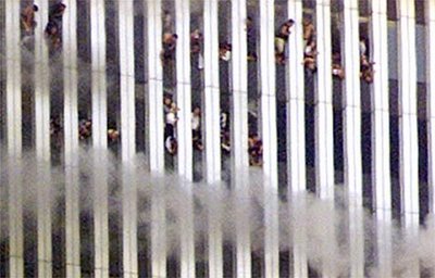 A close-up showing people looking out of the burning North tower of the World Trade Center. Shortly after the photo was taken this tower collapsed.