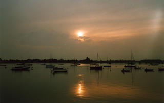 Sailing boats at anchor in the harbour at Bosham on a calm summer's evening.