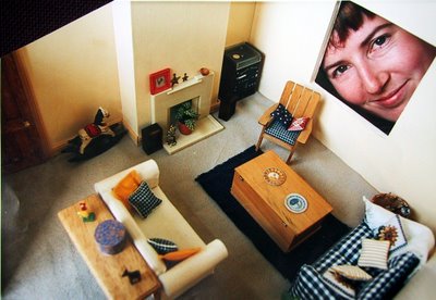 Modern dolls' house miniautre lounge, with a person looing through the window.