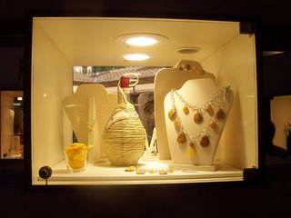 una vetrina della gioielleria con un fiasco di vino toscano