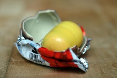 photograph picture how to unwrap and eat a kinder egg surprise. what is inside the egg?