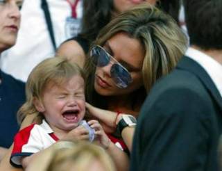 Victoria Beckham comforts her son Romeo during England's Group B Euro 2004 soccer match against France at the Luz Stadium in Lisbon June 13, 2004. David Beckham missed a penalty in England's 2-1 loss to France. REUTERS/Darren Staples 
