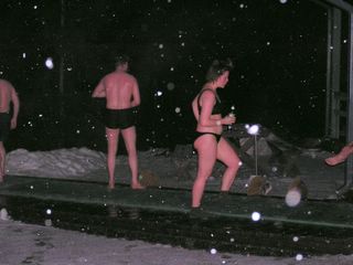 People standing around outside, in their swimwear, and it’s snowing