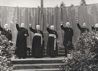 Sacerdotes católicos españoles alzando el brazo para efectuar el saludo fascista durante la dictadura criminal y genocida de Franco