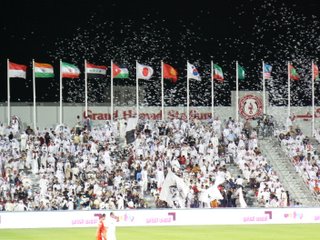 Qatari football supporters demonstrate their enthusiasm by throwing paper into the air