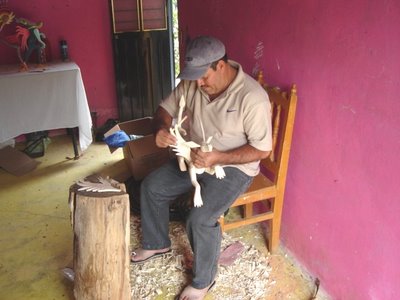 Pale Horse Galleries online store for gifts, collectibles, Mexican art and crafts. http://palehorsemex.vstore.ca/ Fidencio Ojeda, Zapotec sculptor of wooden figures and alebrijes, at work with a new creation in Arrazola, Xoxocotlan, Mexico.