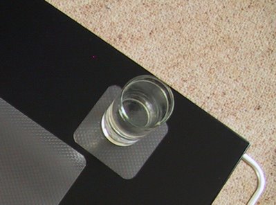 Glass of water on a plastic coaster.
